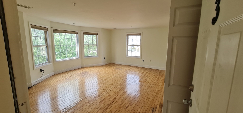 41 West Street, Unit 3 Boston, MA 02136 - Photo 6 of 23 a view of an empty room with wooden floor and a window