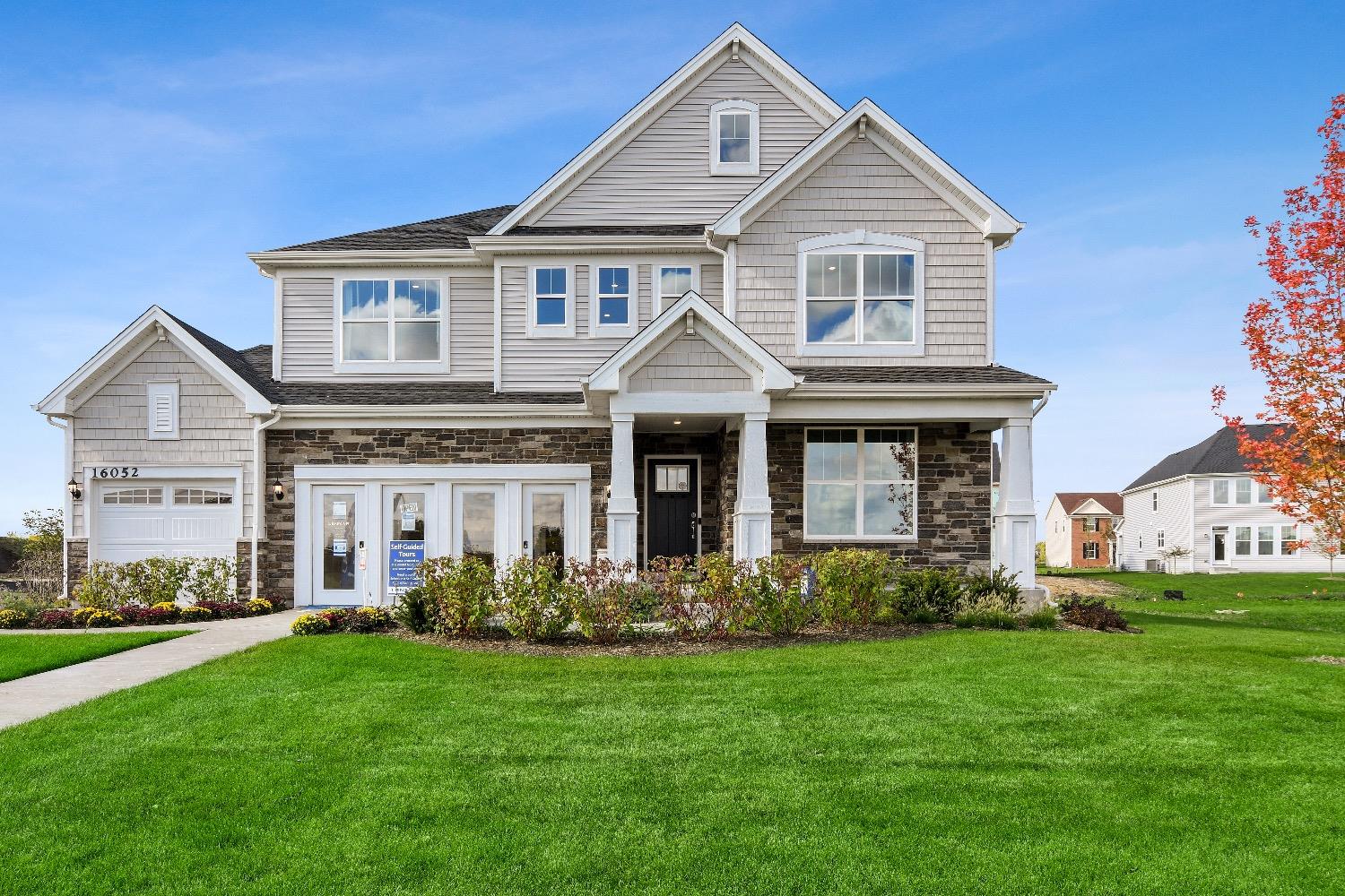 a front view of a house with a garden and yard