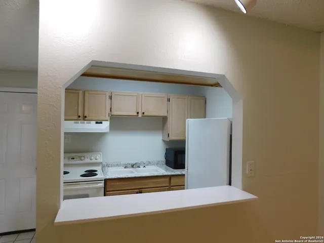 a kitchen with stainless steel appliances a stove a sink and a refrigerator