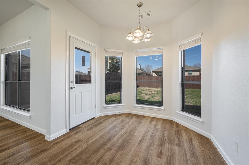826 Hazel's Way Anna, TX 75409 - Photo 11 of 25 a view of an empty room with wooden floor and a window