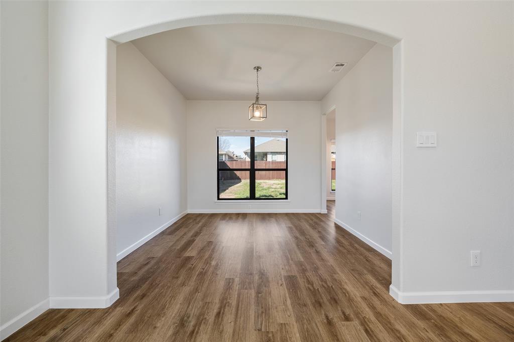 826 Hazel's Way Anna, TX 75409 - Photo 7 of 25 an empty room with wooden floor and windows