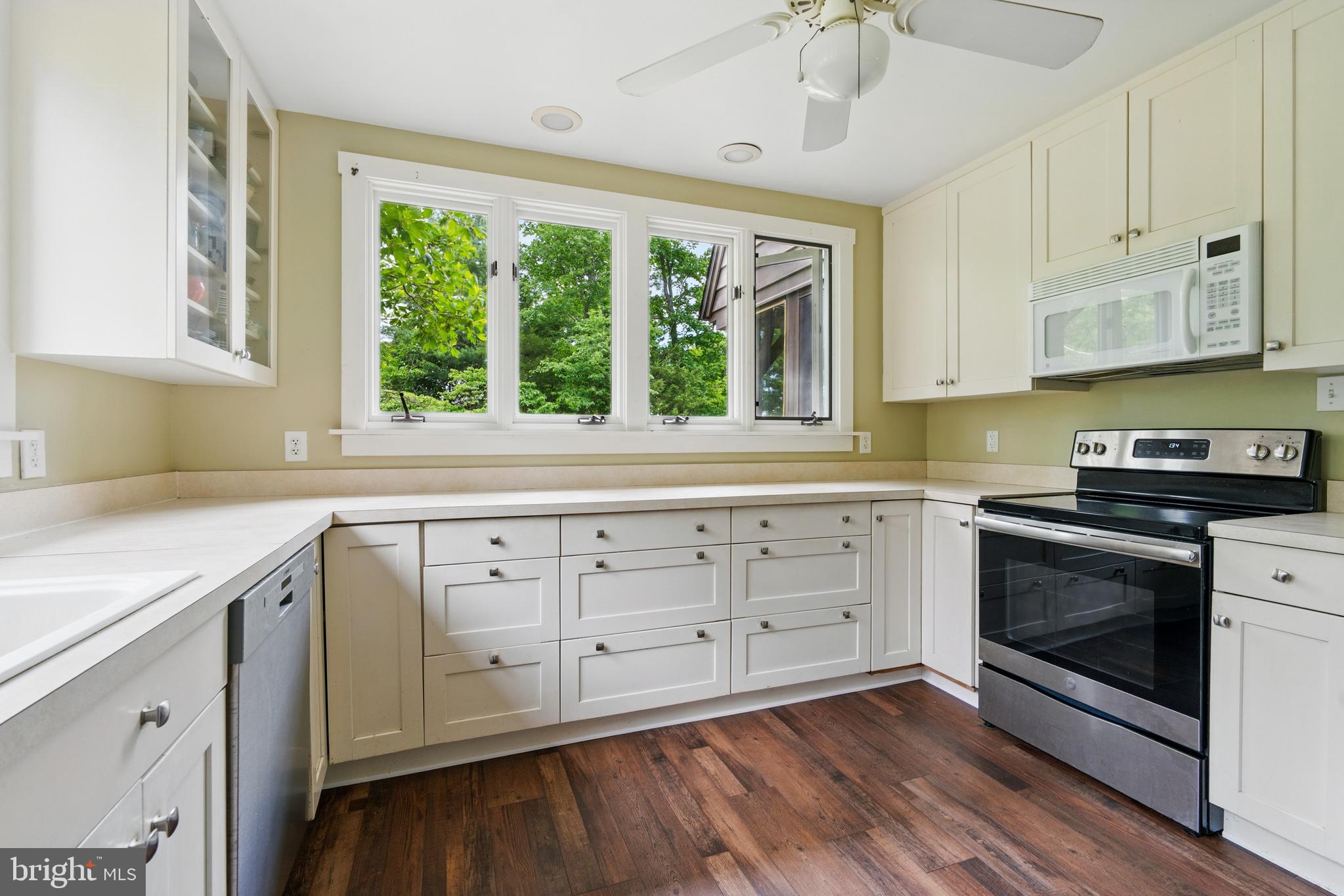 215 Dove Lane Elkton, MD 21921 - Photo 24 of 46 a kitchen with granite countertop a stove a sink and white cabinets with wooden floor