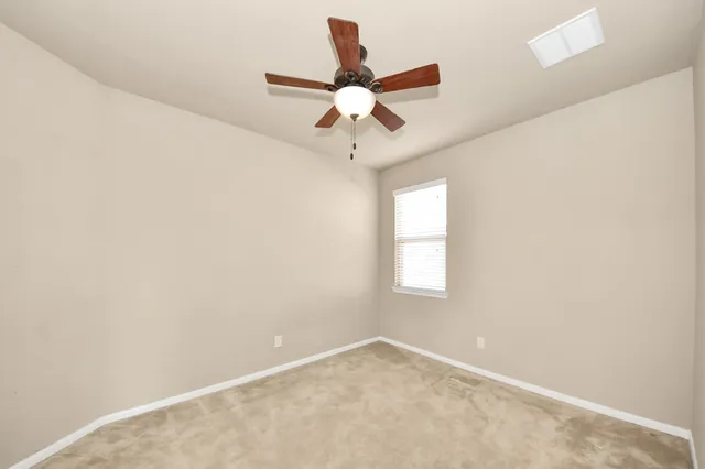 an empty room with a window and a fan