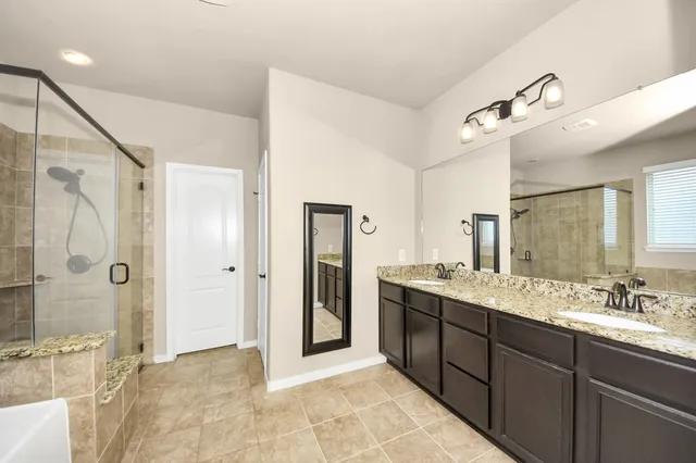 a spacious bathroom with a granite countertop sink mirror and shower