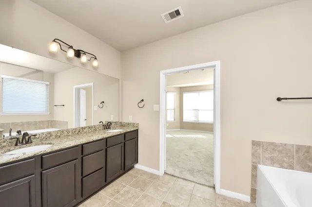a spacious bathroom with a granite countertop sink a mirror and a
