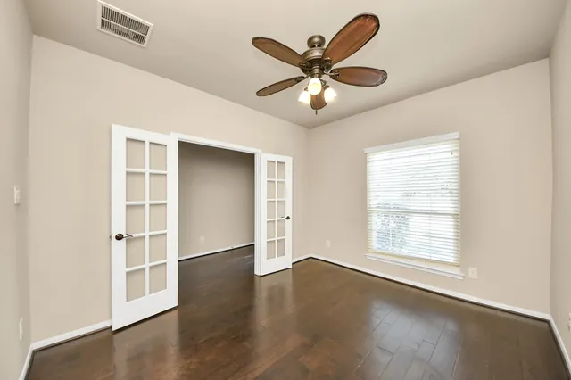 a view of a livingroom with a ceiling fan and wooden floor