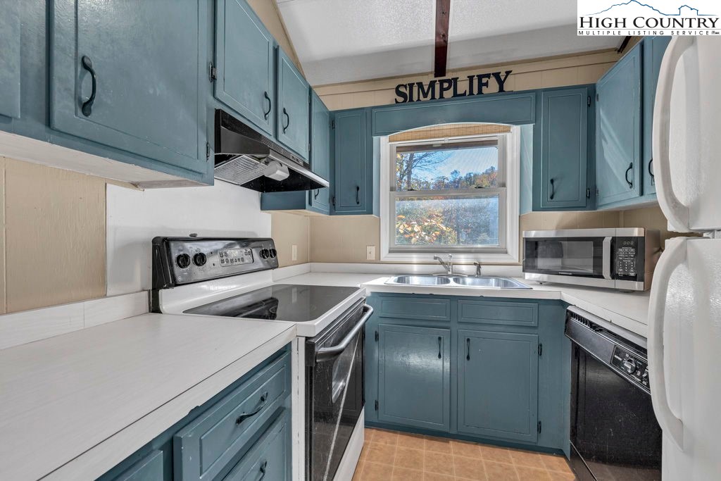 101 Hornbeam Road, Unit 2B Beech Mountain, NC 28604 - Photo 6 of 35 a kitchen with stainless steel appliances granite countertop a sink a stove and a wooden floors