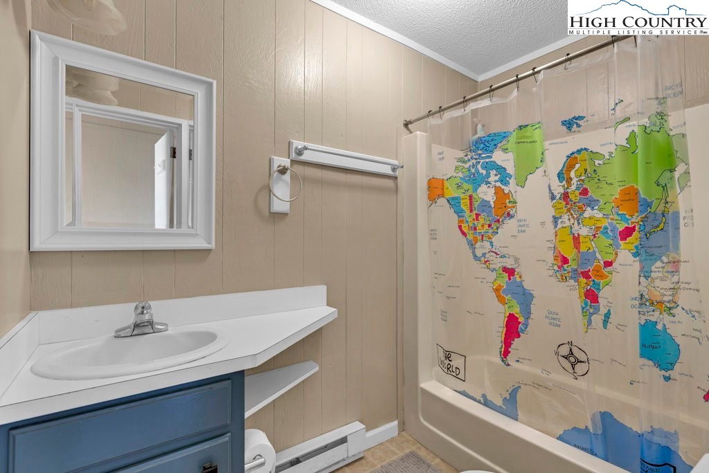 101 Hornbeam Road, Unit 2B Beech Mountain, NC 28604 - Photo 8 of 35 a bathroom with a sink a vanity and a shower curtain