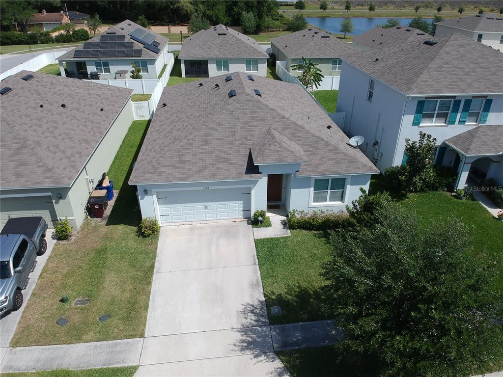 an aerial view of a house with yard porch and furniture