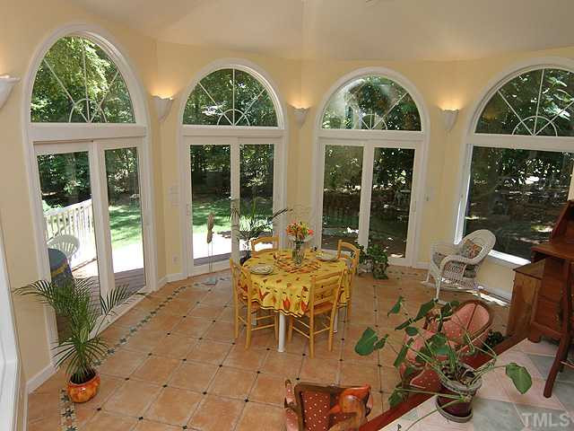8616 Harbor Drive Raleigh, NC 27615 - Photo 3 of 25 Bright Sun Room 19.5x13.5 Features Sliding French Doors with Arched Effects opening to Deck, Decorative Sconce Up-lighting, Ceiling Fan, Tile Floor, opens to Family Room. Sun Room