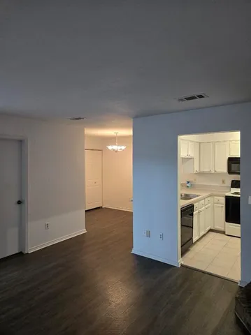 a view of a kitchen with wooden floor and a sink