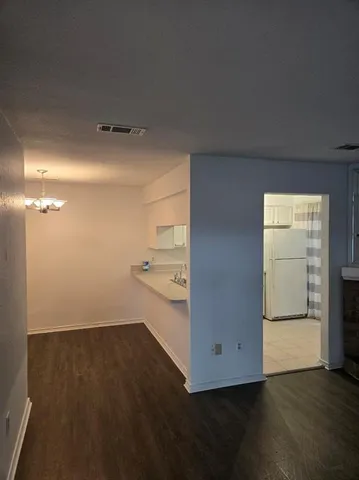 a view of an empty room and wooden floor