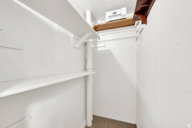 446 South 300 East Provo, UT 84606 - Photo 19 of 32 Interior storage space featuring multiple white shelves, a white hanging rod, and light brown carpeting
