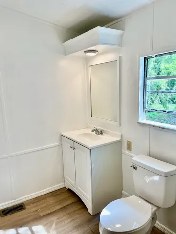 a bathroom with a sink a toilet a mirror a bathtub and shower