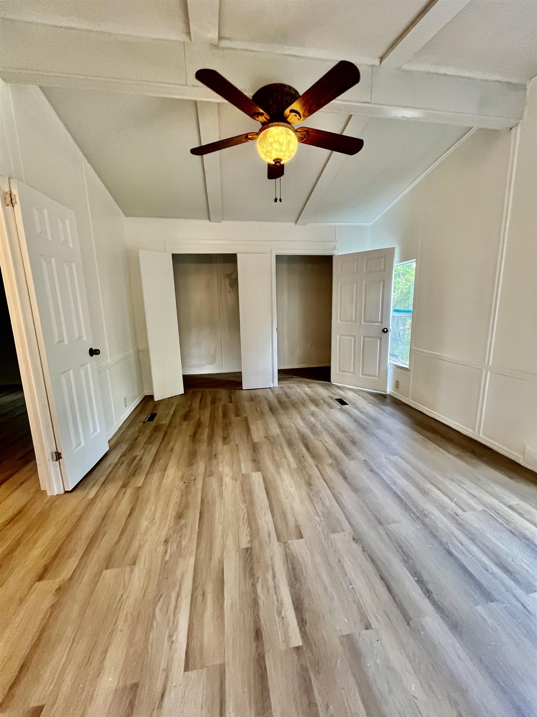 23670 Northeast 154th Place Road Salt Springs, FL 32134 - Photo 24 of 65 a view of an empty room with wooden floor and a ceiling fan