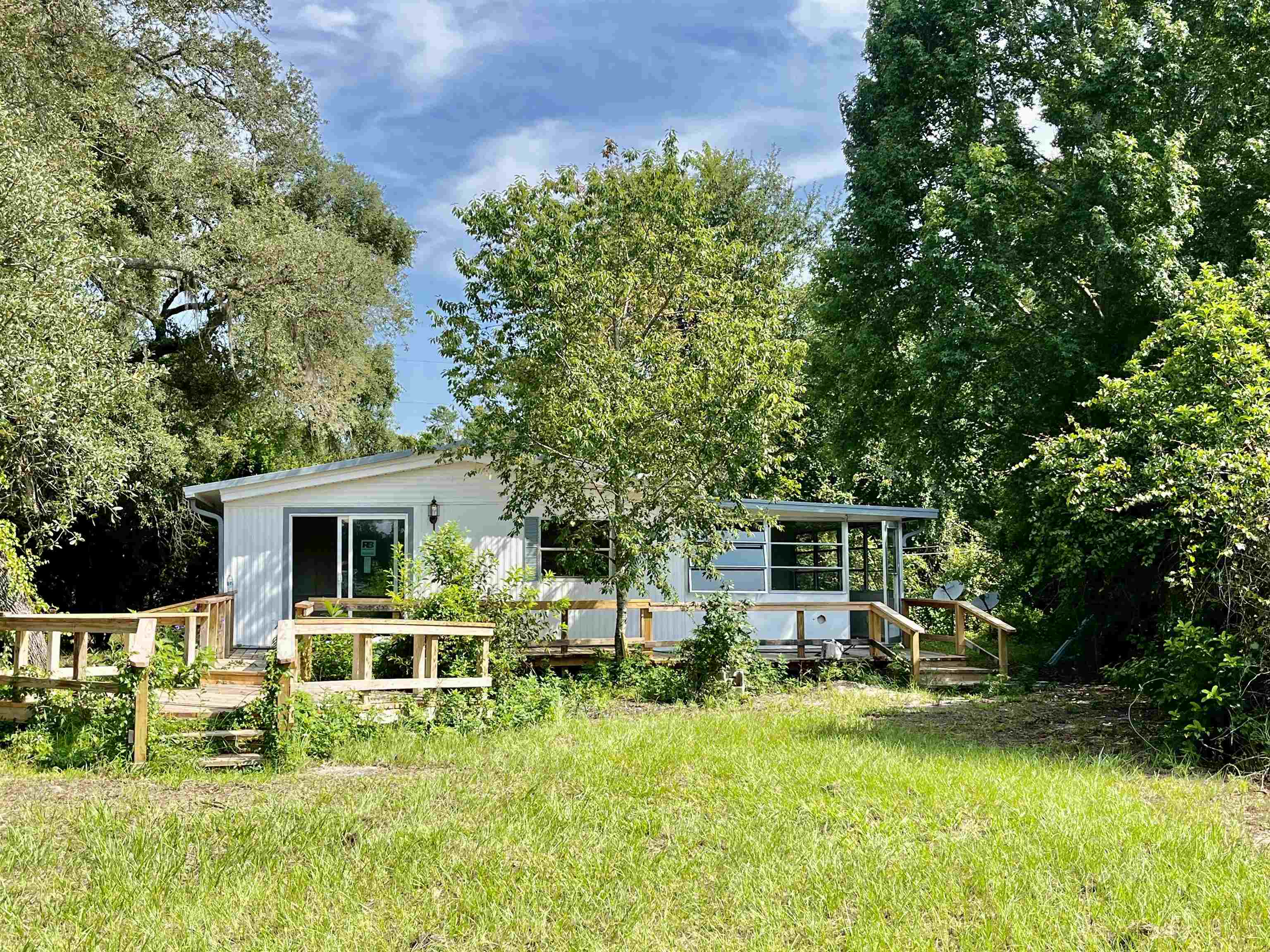 23670 Northeast 154th Place Road Salt Springs, FL 32134 - Photo 4 of 65 a front view of a house with a yard table and chairs