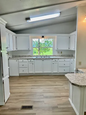 a kitchen with granite countertop a stove and cabinets