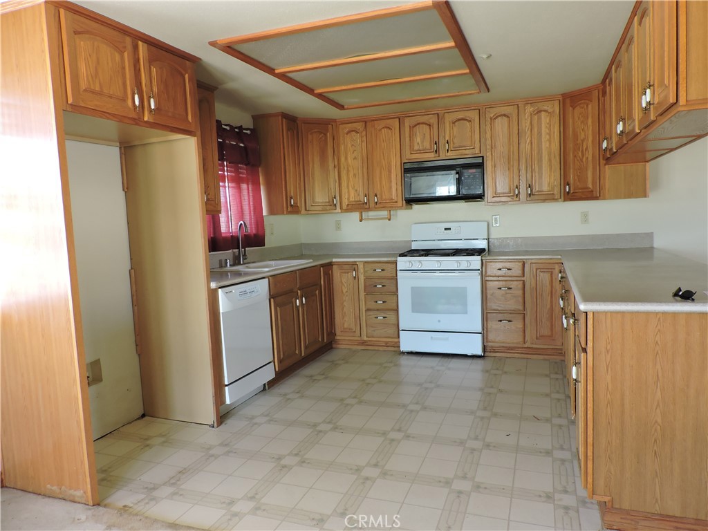 5480 Sunnyslope Road Phelan, CA 92371 - Photo 6 of 47 a kitchen with stainless steel appliances granite countertop a stove top oven a sink and dishwasher