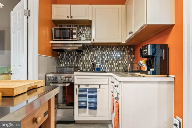 a kitchen with stainless steel appliances granite countertop a stove and a microwave