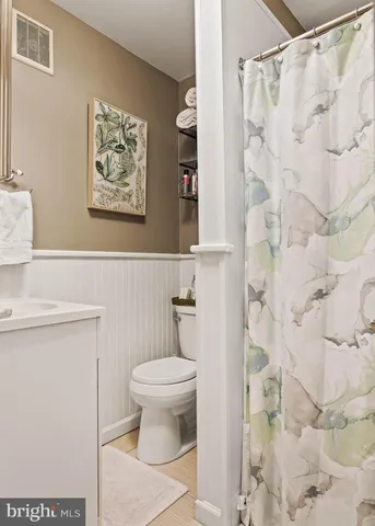 a bathroom with a toilet and a shower curtain
