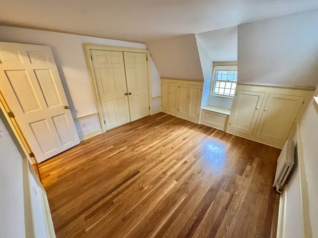 a view of empty room with window and wooden floor