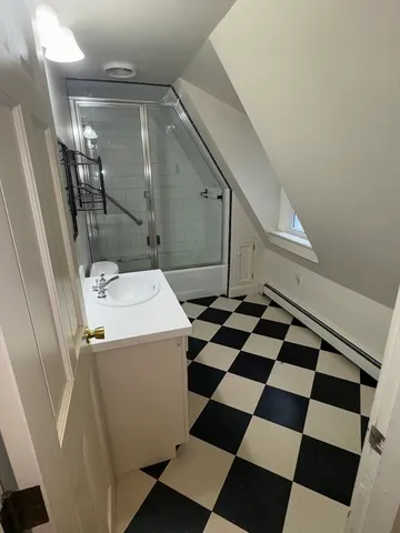 a storage and utility room with a black white checkered floor