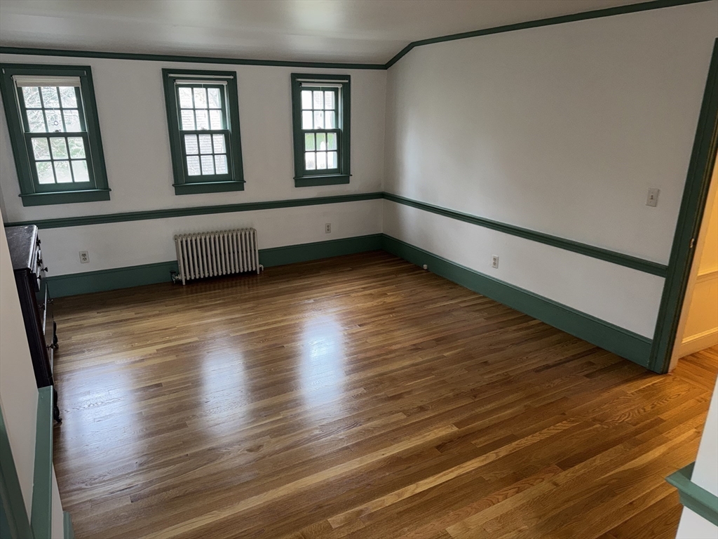 191 Chestnut Street, Unit 1 Duxbury, MA 02332 - Photo 19 of 20 a view of an empty room with wooden floor and a window