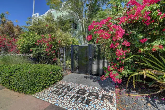 a backyard of a house with table and chairs plants and swimming pool