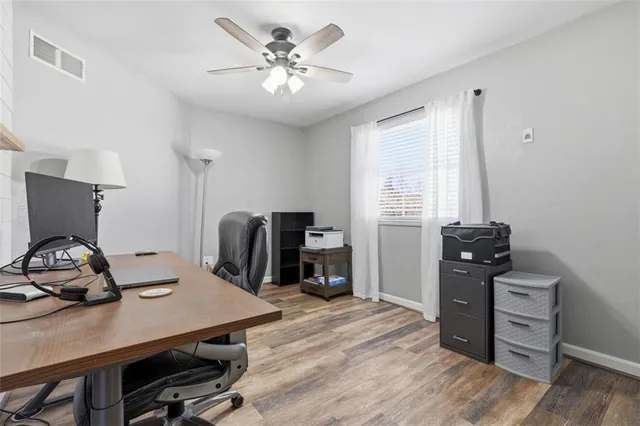 a view of a workspace with furniture and a window
