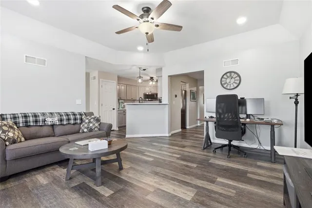 a living room with furniture a clock and a table