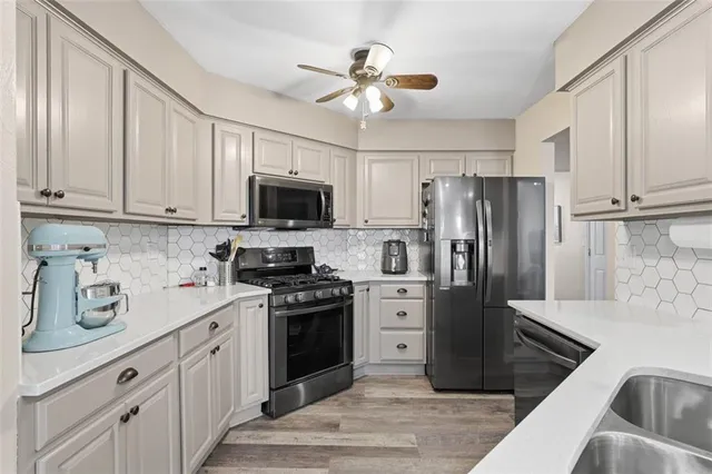 a kitchen with stainless steel appliances granite countertop a refrigerator a stove a sink dishwasher and a refrigerator with wooden cabinets