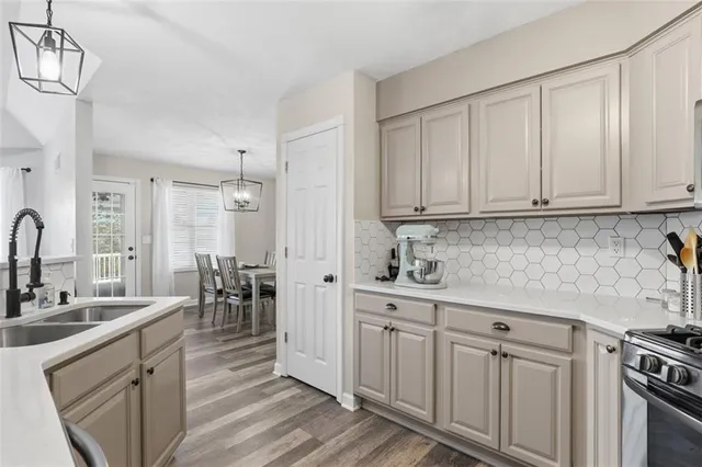 a kitchen with white cabinets and sink