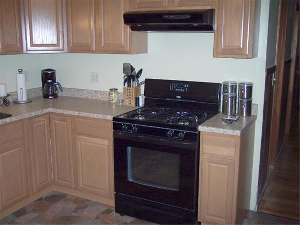11 Ridgeview Road West Springfield, MA 01089 - Photo 8 of 9 a kitchen with stainless steel appliances granite countertop white cabinets and black stove top oven with wooden floor