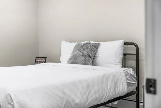 a bedroom with a bed and painting on the wall