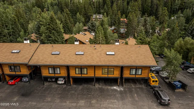 an aerial view of a house with a yard and large tree