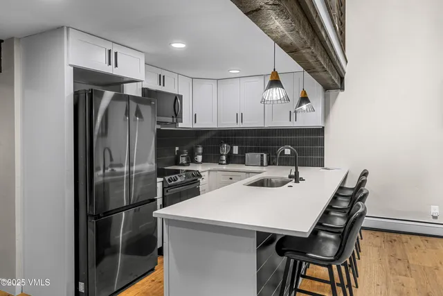 a kitchen with stainless steel appliances granite countertop a sink a stove and a refrigerator