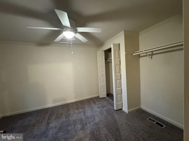 an empty room with closet and windows