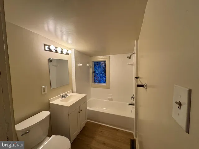a bathroom with a bathtub shower sink mirror and toilet