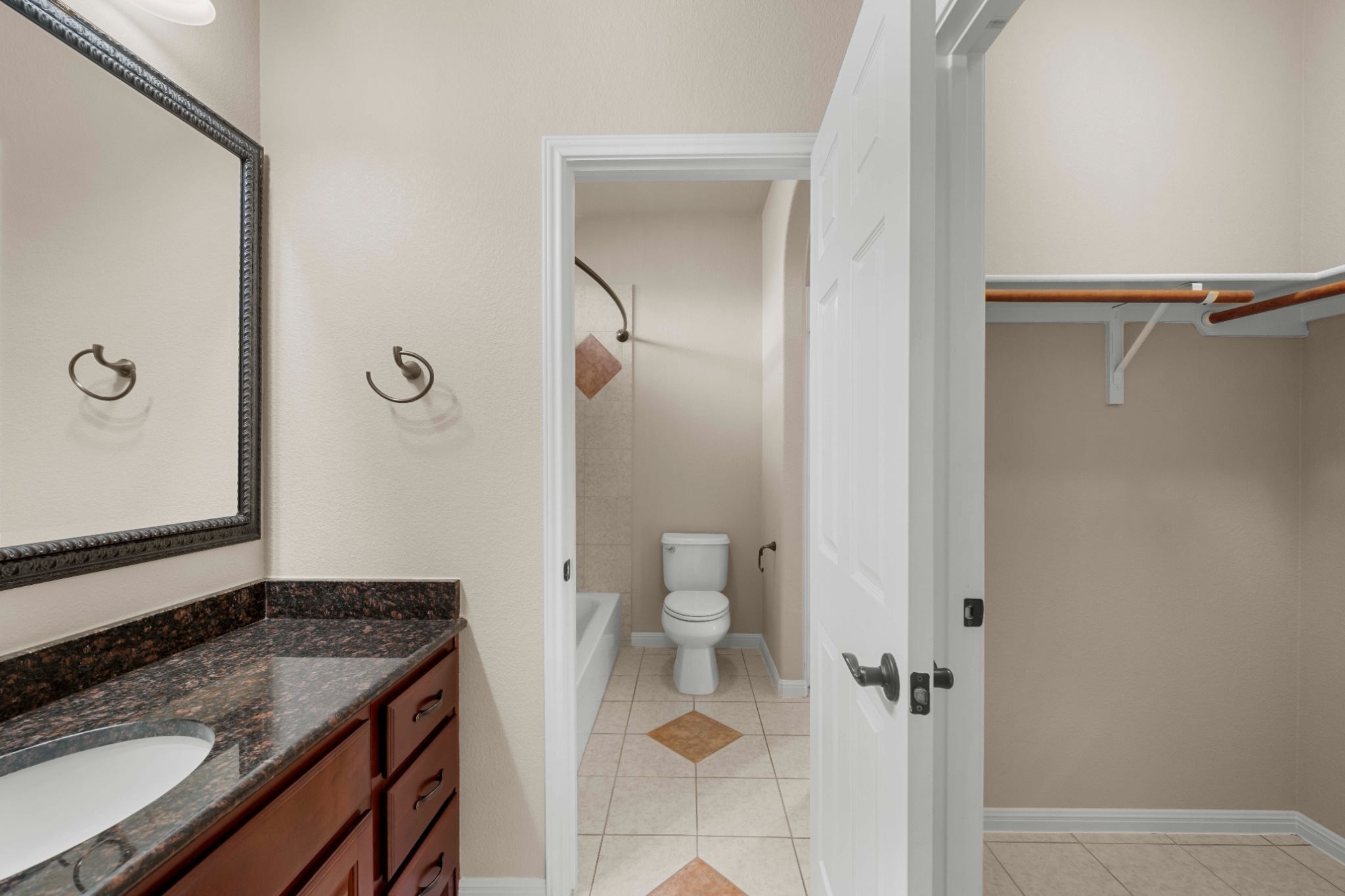 3903 Remington Road Cedar Park, TX 78613 - Photo 22 of 29 Well-appointed bathroom vanity with granite counters and rich wood cabinetry, alongside a tile-floored water closet.