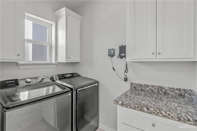 a kitchen with white cabinets and sink