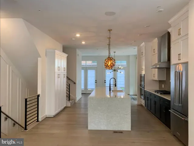 a kitchen with stainless steel appliances granite countertop a refrigerator a oven and a sink