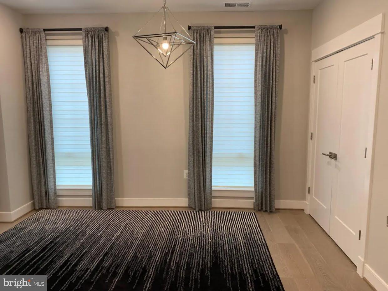 1870 Easterly Road Reston, VA 20190 - Photo 3 of 33 an empty room with wooden floor door and way to kitchen