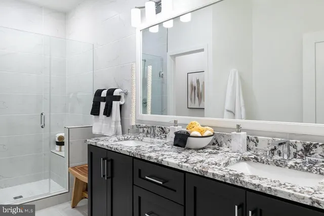 a bathroom with a granite countertop sink and a mirror