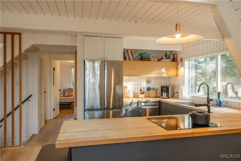 a kitchen with stainless steel appliances granite countertop a sink and a refrigerator
