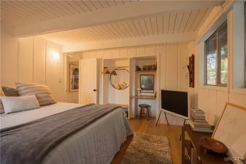 a bedroom with a bed and a flat screen tv