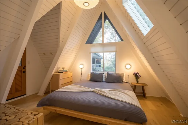 a bedroom with a bed and a large window
