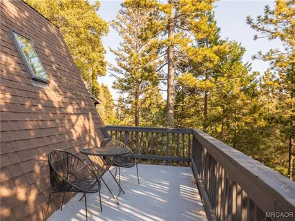 a balcony with wooden floor table and chairs
