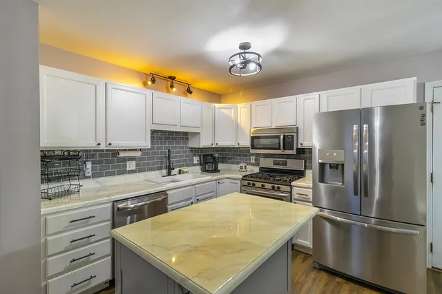 a kitchen with a refrigerator a sink and cabinets
