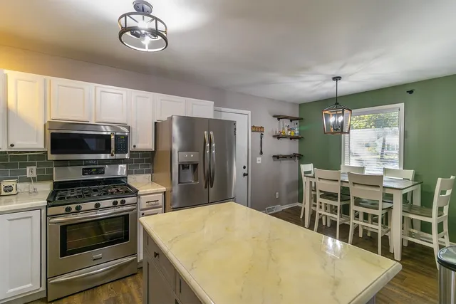 a kitchen with stainless steel appliances a stove a microwave and a refrigerator