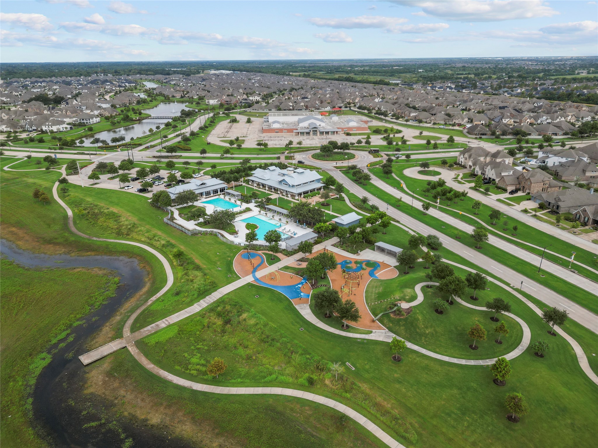 2011 Oak Leaf Court Manvel, TX 77578 - Photo 27 of 28 Picturesque residential community with a large recreational complex featuring a pool, playground, and lush green spaces. The neighborhood is well-planned with winding roads and numerous homes, offering a vibrant yet serene living environment.